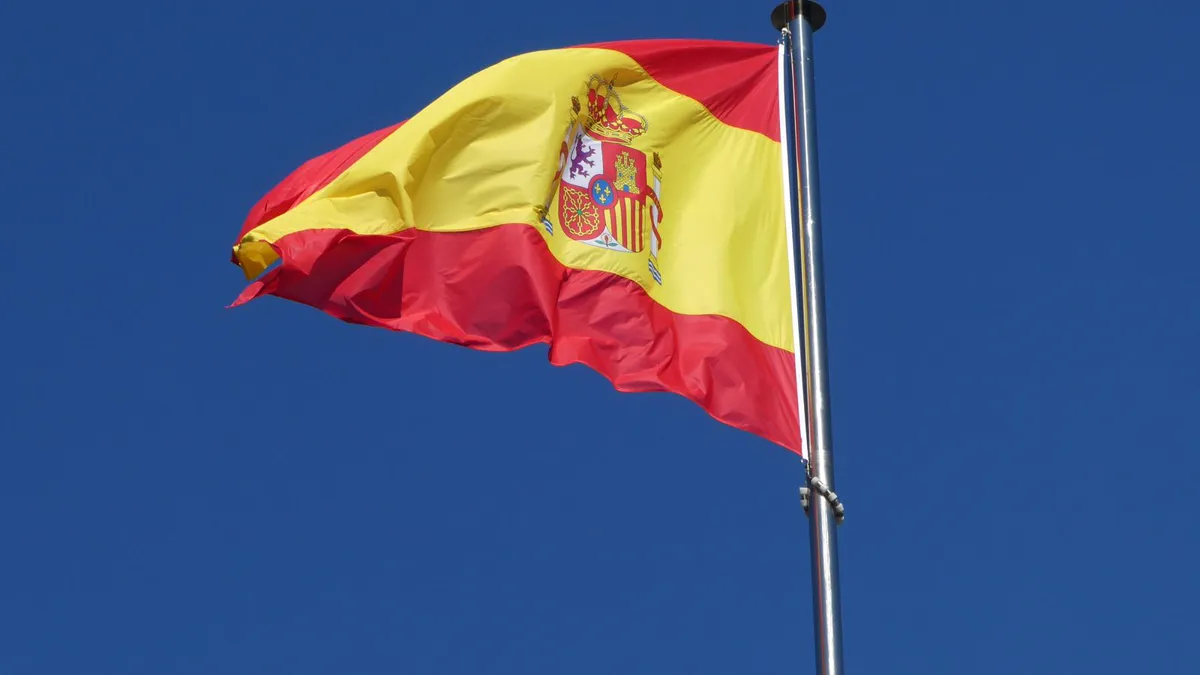 Bandera de España ondeando contra un cielo azul