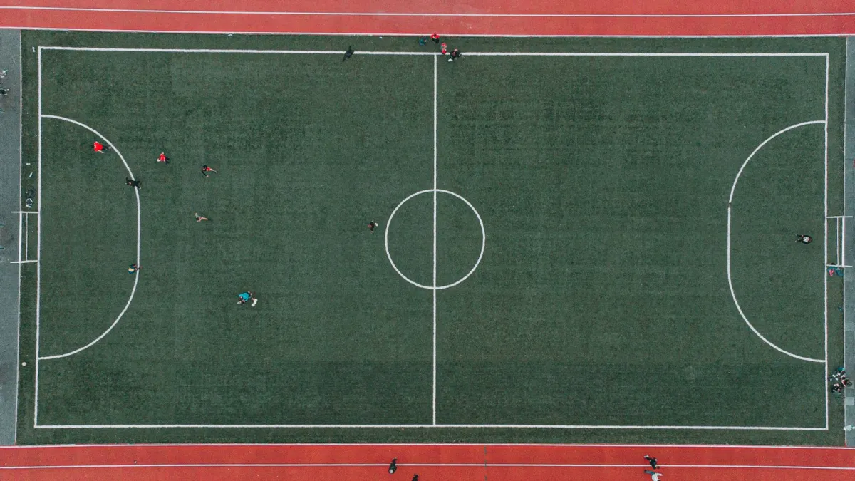 Campo de fútbol 7 visto desde arriba con los jugadores repartidos por el terreno